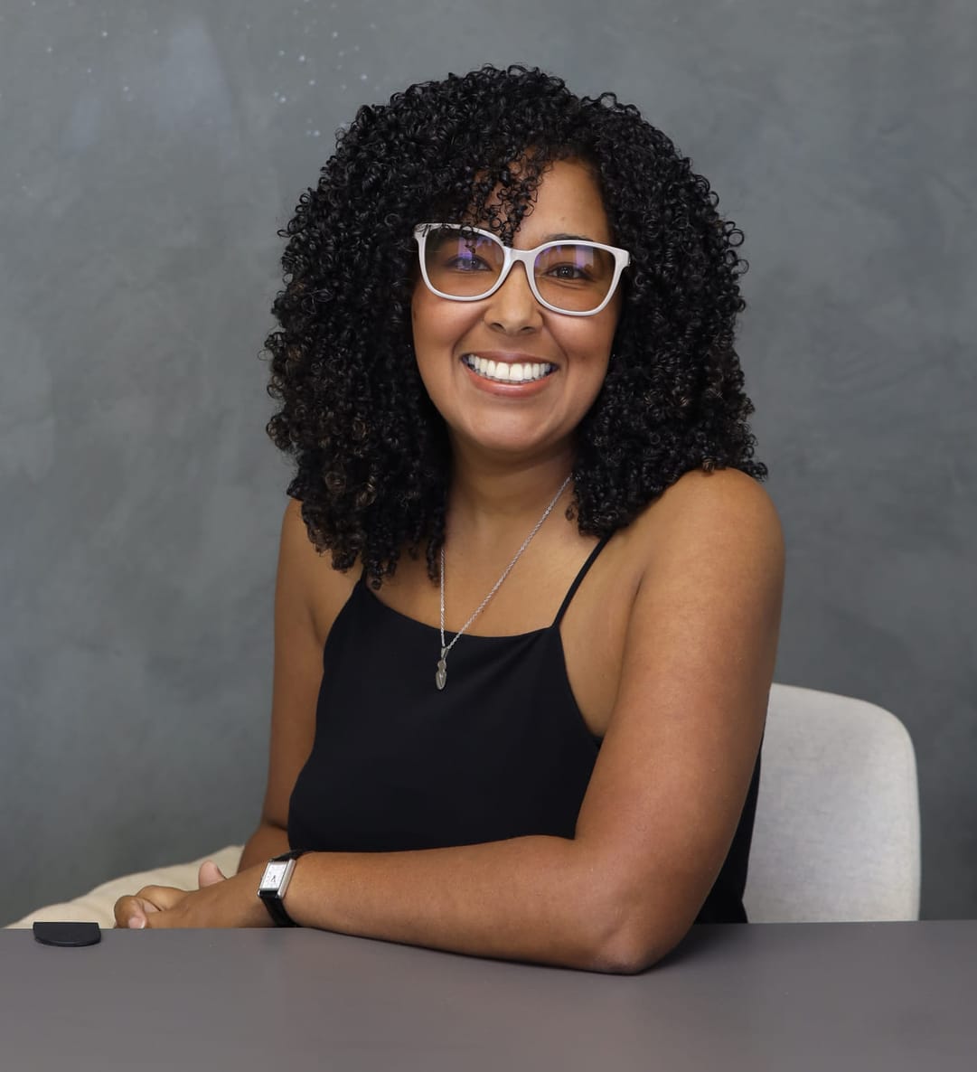 Lcda. Linda De Jesús Casiano sentada a su escritorio, sonriendo